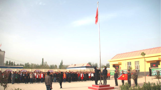 The people in a locality in Xinjiang are organized to hold a flag raising ceremony(Online image)