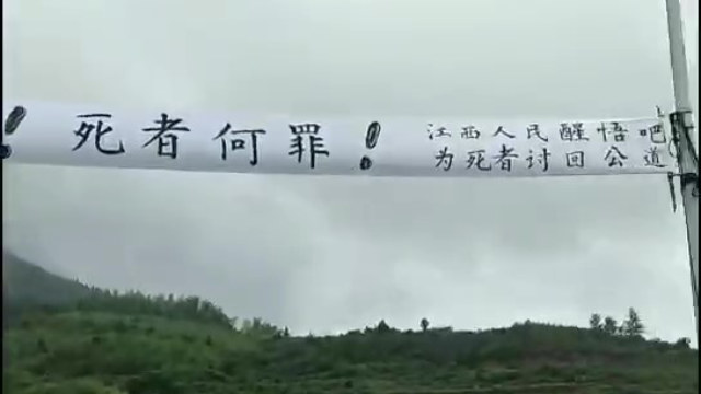 The protesting villagers displayed a banner calling on to seek justice for the dead.
