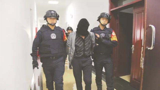 Public security officers ar arresting and escorting a prisoner to the interrogation room