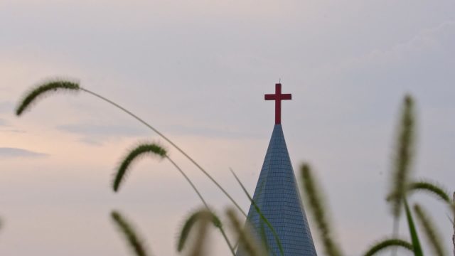 A cross on the roof of a Christian church