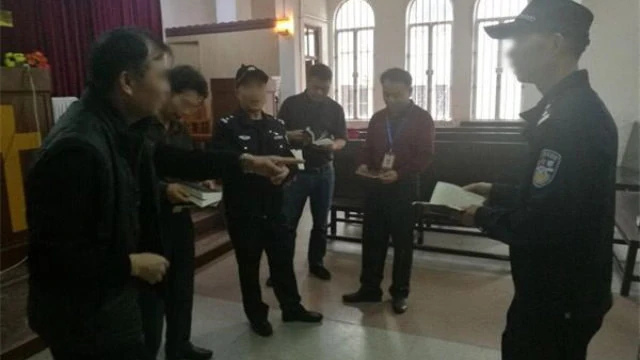 Officials and police officers remove religious publications from a church in Guangdong’s Enping city.